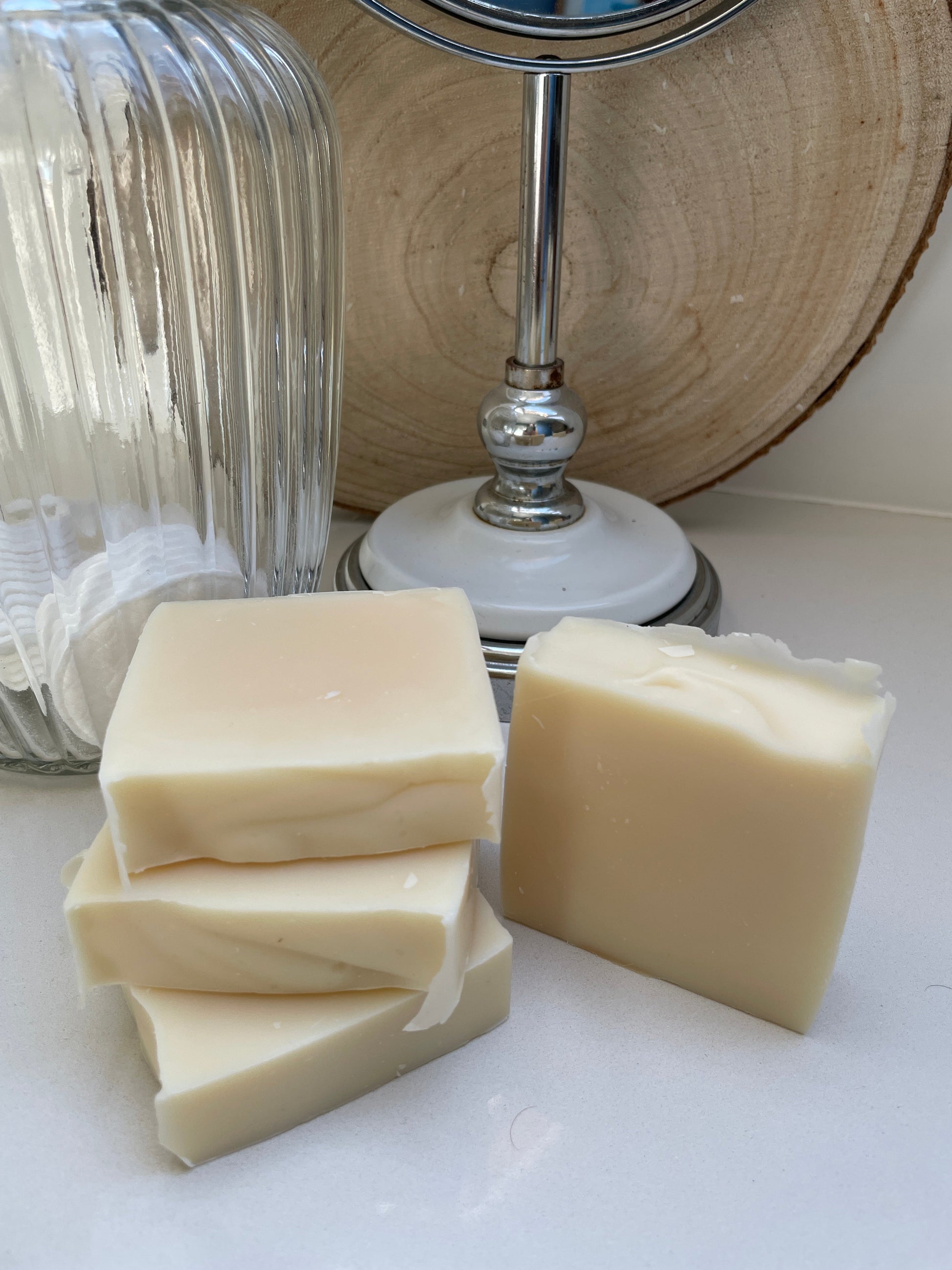 Four bars of environmentally friendly handmade lavender, lemongrass & rosemary soap bars displayed on a bathroom surface.