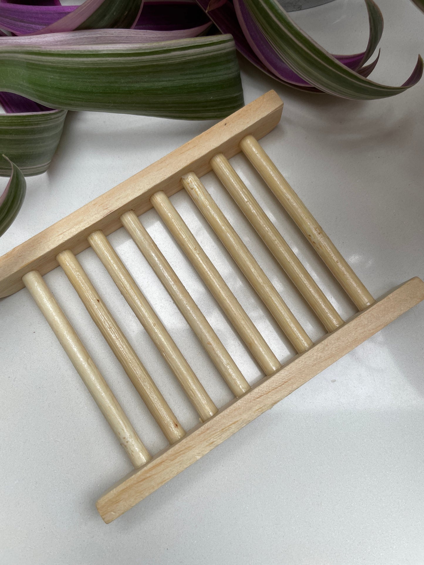 A light brown wooden soap dish with a laddered dowel design.