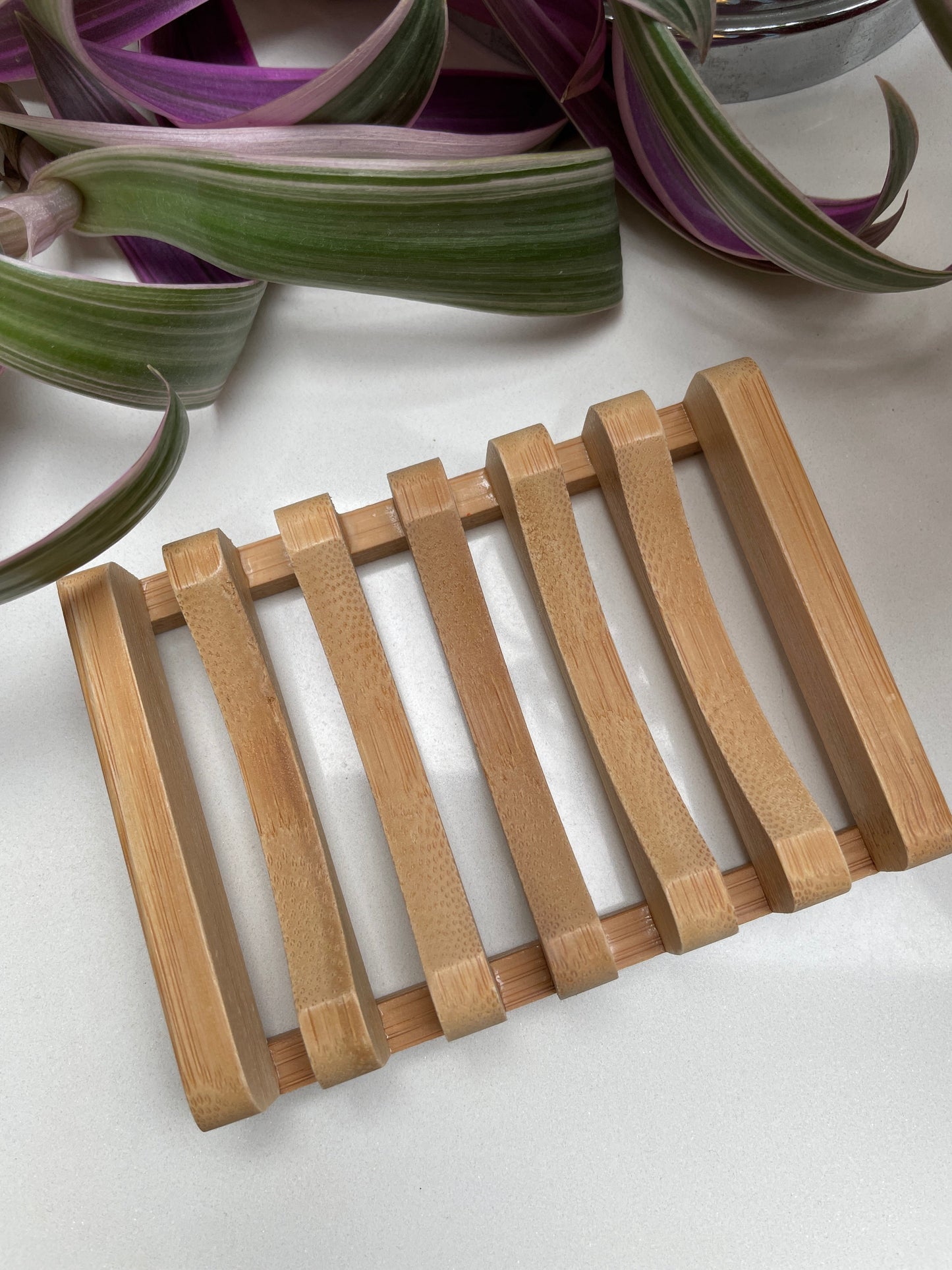 A light brown wooden soap dish with a square slatted design.